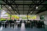 ein Restaurant mit Tischen und Stühlen in einem Raum in der Unterkunft Khaosok River Stone Resort & Camp in Ban Thung Lang Tham