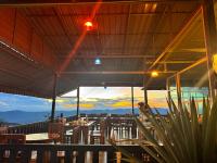 Un restaurante con mesas y sillas y vista a las montañas. en ลักษณ์ภูชี้ฟ้า 2, en Ban Seng Choi