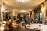 Un comedor con mesas y sillas y ventanas. en Hotel Mariuccia, en Varese