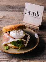 Un sándwich con un huevo en un plato con un libro. en Logement The Black Tie, en Assen