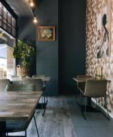 Un restaurante con paredes de color verde oscuro y mesas y sillas de madera. en Logement The Black Tie, en Assen