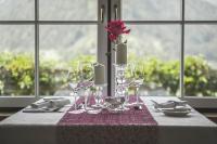 ザンクト・ヨーハン・イム・ポンガウにあるHotel AlpenSchlösslのワイングラスとバラの花瓶