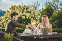 ザンクト・ヨーハン・イム・ポンガウにあるHotel AlpenSchlösslのワイングラスを持ってテーブルに座っている男女