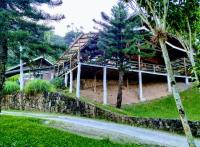 Hotel Pousada Fazendinha في نازاريه باوليستا: مبنى منتجع ذو جدار حجري وأشجار نخيل