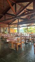 Hotel Pousada Fazendinha في نازاريه باوليستا: مطعم فارغ مع طاولات وكراسي خشبية