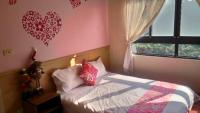 a bedroom with a bed with pink walls and a window at 甘丹民宿-三義火車站前 in Sanyi