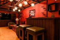 een bar met krukken in een kamer met rode muren bij The Plix Resort in Morjim