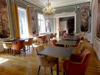 Un restaurante con mesas y sillas y una lámpara de araña. en Domaine de la Tremblère, en Arthon