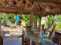 una mesa con platos de comida bajo una sombrilla en Villa Sylkomba 1, en Nosy Komba