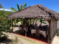 un restaurante con una mesa y techo de paja en Villa Sylkomba 1, en Nosy Komba