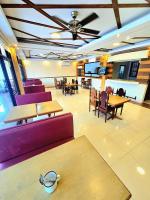 プエルト・プリンセサにあるHola Hostel Puerto Princesaの木製のテーブルと紫色の椅子とテーブルのあるレストラン