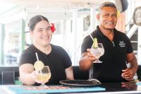 un hombre y una mujer sosteniendo copas de vino en Hotel Millenia Samoa, en Apia
