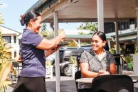 Una mujer sentada en una mesa con un hombre tomando una foto. en Hotel Millenia Samoa, en Apia