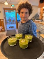 Un hombre sentado en una mesa con cuatro bebidas en una bandeja. en Hôtel Restaurant Gîtes Les 5 Saisons, en Freissinieres