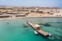 an aerial view of a beach with a dock in the water at Marsa Shagra Village in Abu Dabab