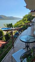einen Balkon mit Tischen und Blick auf das Wasser in der Unterkunft Pensiunea Delfinul in Văleni