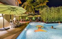 una piscina en un hotel con una persona en el agua en Oriva Sarala Crown - 500M From Calangute Beach, en Calangute