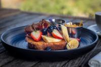 ein blauer Teller mit Essen, darunter Früchte auf Toast in der Unterkunft Thali Thali Game Lodge in Langebaan