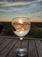 ein Glas Wasser auf einem Tisch mit Sonnenuntergang in der Unterkunft Thali Thali Game Lodge in Langebaan