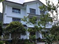 a white house with trees in front of it at 闕麒景觀民宿Chill Villa B&amp;B in Puli