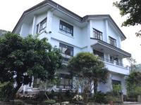 a white building with trees in front of it at 闕麒景觀民宿Chill Villa B&amp;B in Puli