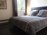 ein Bett mit einer karierten Decke und Kissen darauf in der Unterkunft Bed and Breakfast Le patio in Montigny-lès-Metz