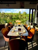 Un comedor con mesa y sillas y una gran ventana. en Hoang Thien Homestay & Sport, en Bao Loc