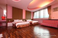 a hotel room with two beds and a couch at Foot Track Bed and Breakfast in Hualien City