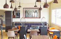 Un restaurante con mesas y sillas y un espejo. en Kyriad Belfort Centre Gare, en Belfort