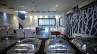 un restaurante con mesas y fregaderos de acero inoxidable en KIIT Residency Patia, Bhubaneswar, en Bhubaneshwar