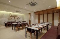 Un restaurante con mesas y sillas en una sala. en Aditya Mansingh Inn Morbi, en Morbi