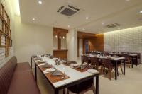 Un comedor con mesas y sillas en un restaurante. en Aditya Mansingh Inn Morbi, en Morbi