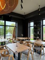 a restaurant with wooden tables and chairs and windows at Готель Горинський 