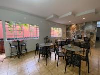 een eetkamer met tafels en stoelen en ramen bij Une Hotel in Uberlândia