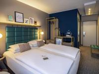 Un dormitorio con dos camas y una pared azul. en Mercure Wien Zentrum, en Viena