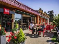 dos personas sentadas en una mesa fuera de un restaurante en ibis Colmar Est - Hotel Restaurant en Alsace, en Colmar