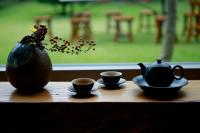 a table with three cups of tea and a vase at Pretty Sun B&amp;B in Ji&#39;an