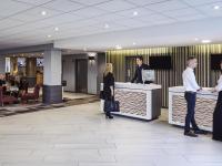 a group of people standing at a counter in a lobby at Novotel Wolverhampton City Centre in Wolverhampton