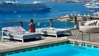 two beds on a deck next to a pool with a cruise ship at Tharroe of Mykonos Boutique Hotel in Mýkonos City