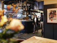 Un hombre y una mujer de pie frente a un bar. en ibis Amsterdam Centre, en Ámsterdam