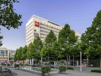 Un edificio alto con árboles delante. en ibis Dresden Zentrum, en Dresden