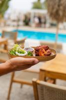 a person holding a plate with food on it at Luxury Boutique Jacuzzi Chalet in Maro