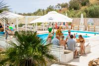 a group of people sitting around a swimming pool at Luxury Boutique Jacuzzi Chalet in Maro
