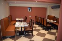 a restaurant with tables and chairs in a room at Hotel Skyview in Kondapur