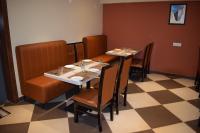 a dining room with two tables and chairs and a checkered floor at Hotel Skyview in Kondapur