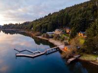 Una vista aérea de un río con casas y un muelle. en Cabañas Puerto Pireo, en San Carlos de Bariloche
