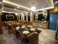 um restaurante com uma sala de jantar com mesas e cadeiras em Coral Beach Resort Mandarmoni em Mandarmoni