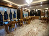 um restaurante com mesas e cadeiras de madeira e janelas em Coral Beach Resort Mandarmoni em Mandarmoni