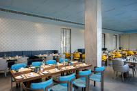a restaurant with wooden tables and blue chairs at Fortune Airport Road Kochi - Member ITC hotels' group in Cochin
