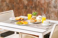 Una mesa de desayuno con alimentos para desayunar y jugo de naranja. en RH Don Carlos & Spa, en Peñíscola